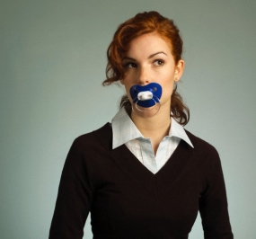 Young woman with pacifier in mouth --- Image by © CJ Burton/Corbis